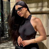 ELAI gold earrings styled outdoors with a black halter top and sunglasses