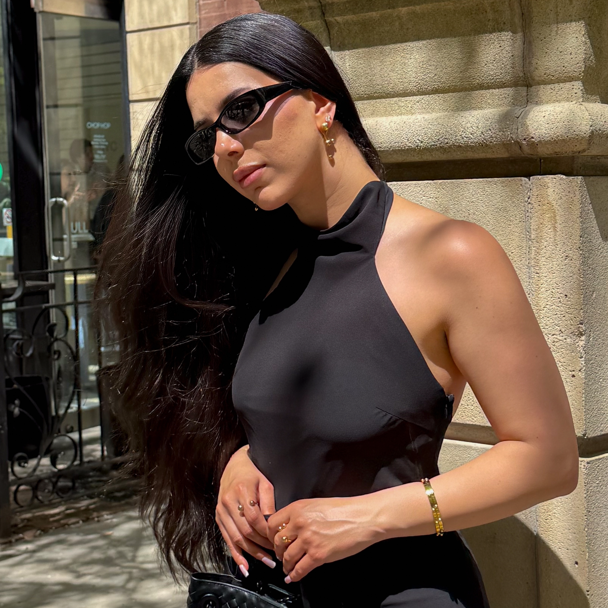 ELAI gold earrings styled outdoors with a black halter top and sunglasses