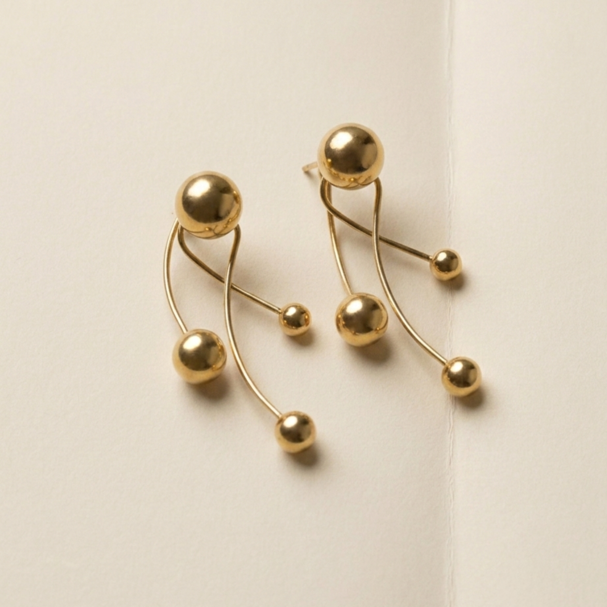 ELAI modular gold earrings shown in the full three-part configuration