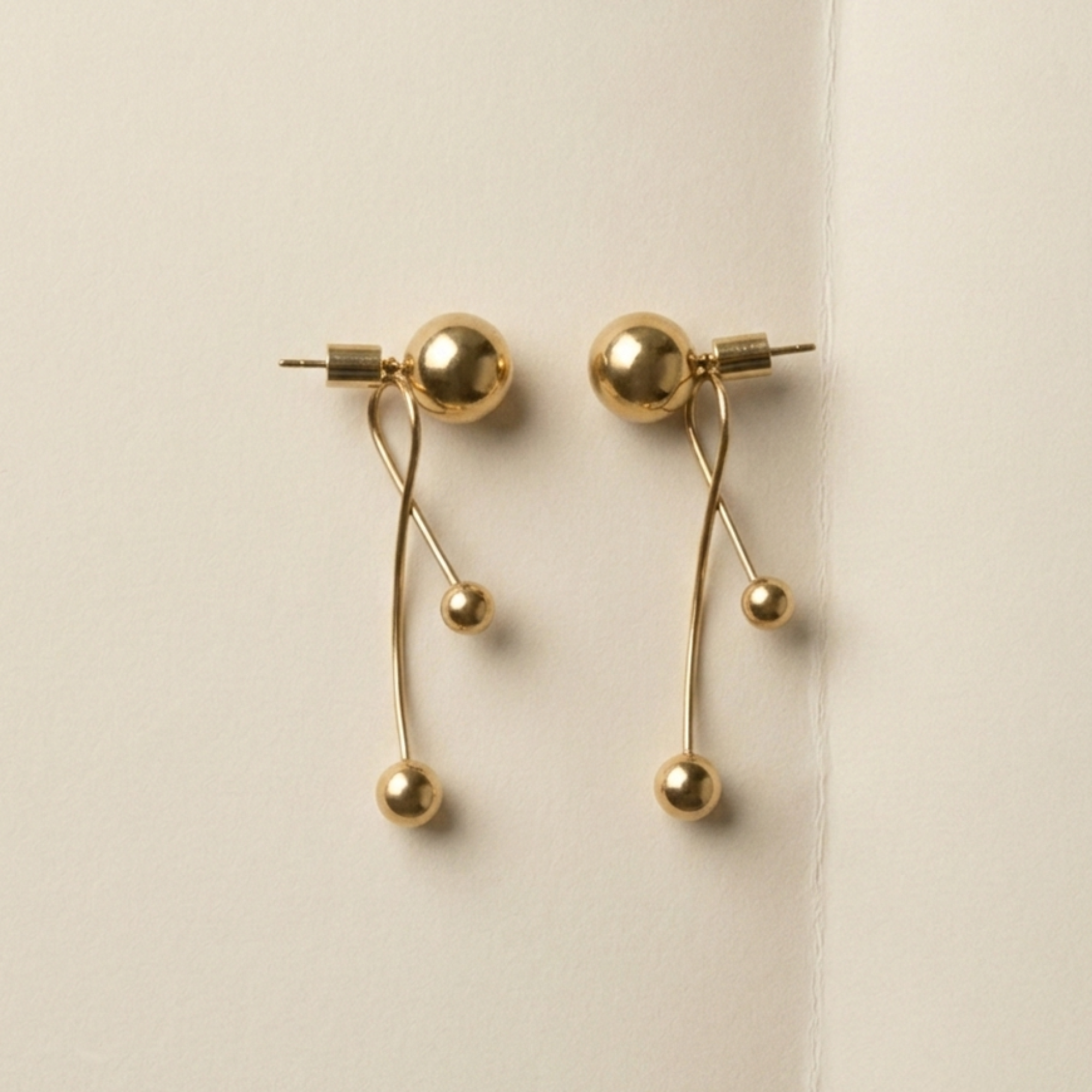 ELAI modular gold earrings shown in an alternate multi-sphere drop configuration
