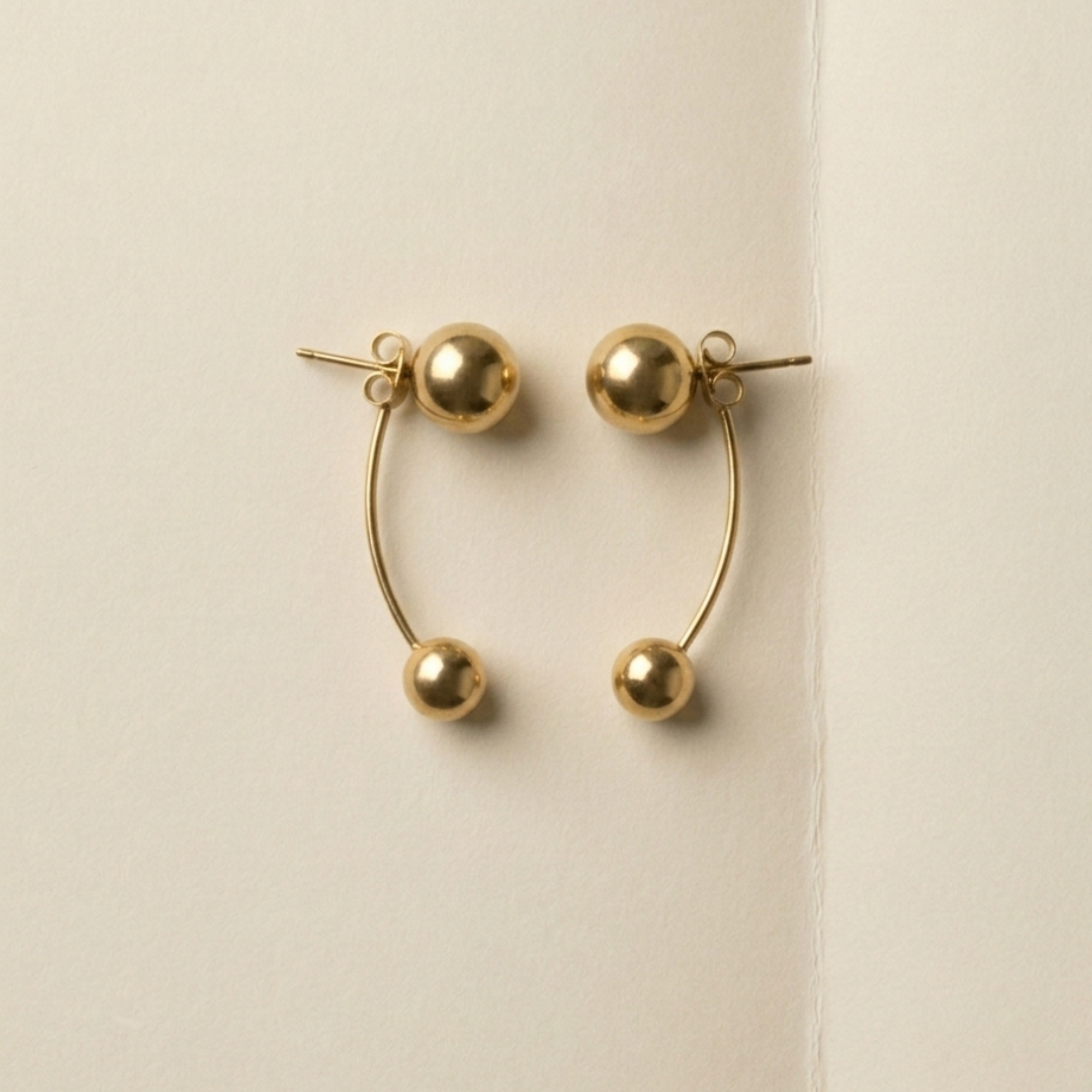 ELAI gold earrings shown in a two-sphere drop configuration